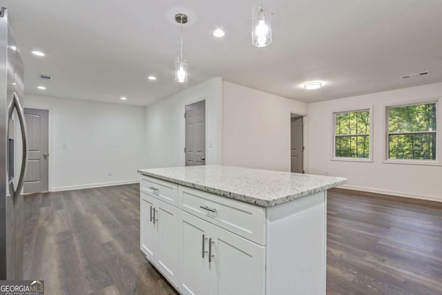 kitchen featuring light stone countertops, stainless steel fridge, dark wood-type flooring, pendant lighting, and white cabinetry