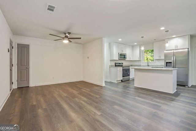 kitchen featuring white cabinetry, a center island, decorative light fixtures, and appliances with stainless steel finishes