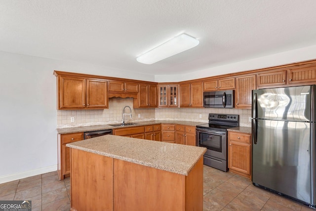 kitchen with a center island, sink, decorative backsplash, light stone counters, and stainless steel appliances