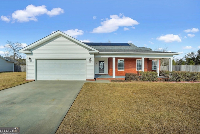 single story home featuring solar panels, a garage, and a front yard