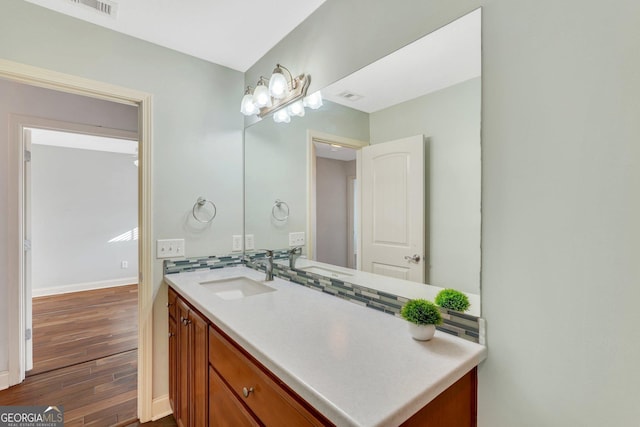 bathroom with tasteful backsplash, vanity, and wood-type flooring