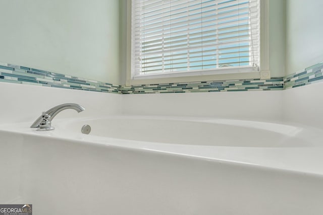 bathroom featuring plenty of natural light and a tub