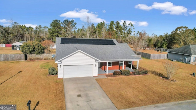 view of front of property with a front lawn, a garage, a porch, and solar panels