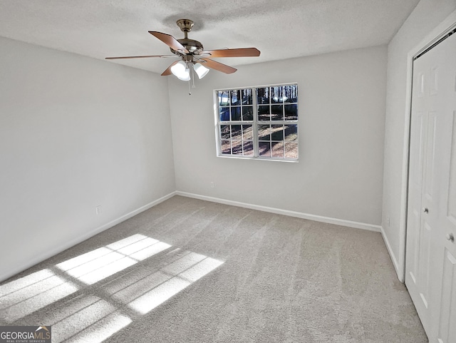 unfurnished bedroom with a textured ceiling, a closet, ceiling fan, and light colored carpet