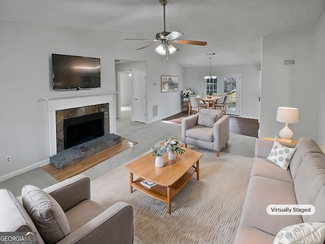 living room with ceiling fan, a fireplace, and lofted ceiling