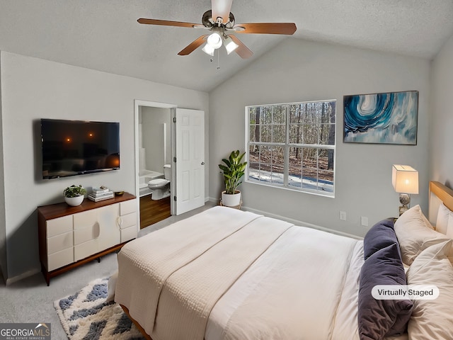 carpeted bedroom with ceiling fan, lofted ceiling, and ensuite bath