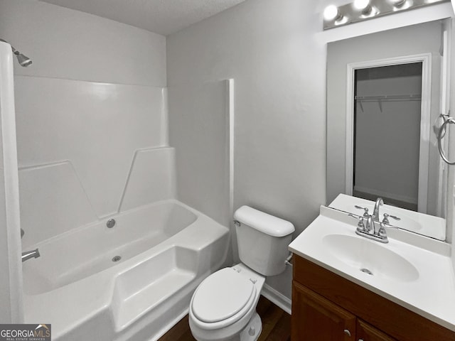 full bathroom featuring vanity, a textured ceiling, bathing tub / shower combination, hardwood / wood-style floors, and toilet