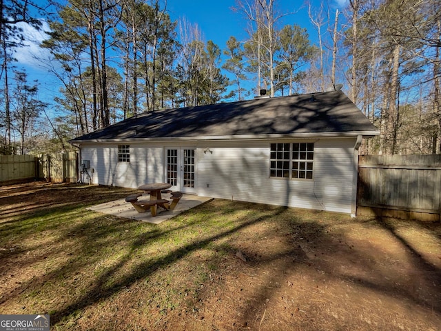 rear view of house featuring a patio area, a yard, and french doors