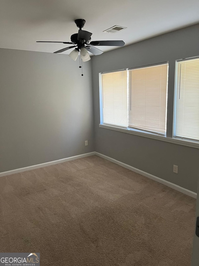 carpeted spare room with ceiling fan