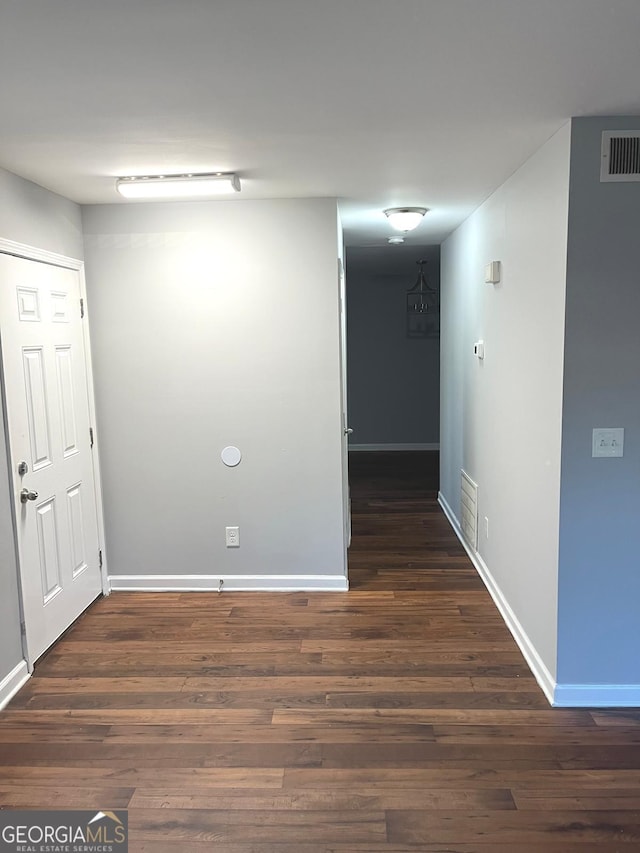 unfurnished room with dark wood-type flooring