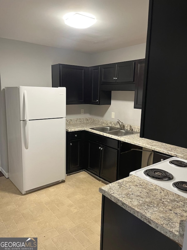 kitchen featuring sink, white fridge, and range