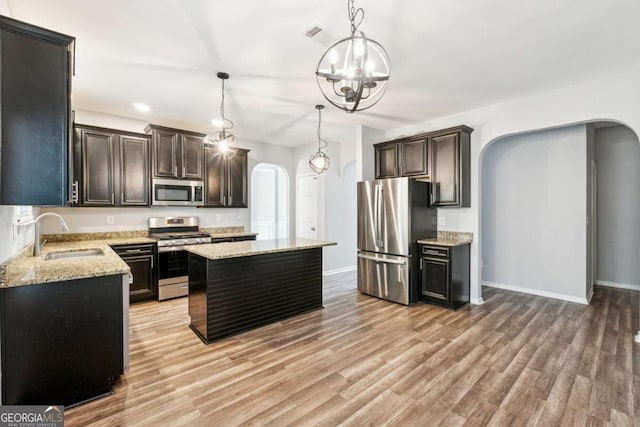 kitchen featuring sink, hanging light fixtures, an inviting chandelier, a kitchen island, and appliances with stainless steel finishes