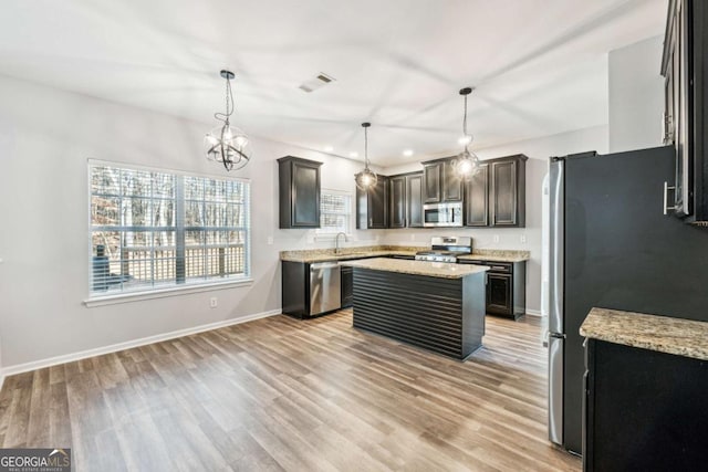 kitchen featuring appliances with stainless steel finishes, dark brown cabinetry, a kitchen island, and sink