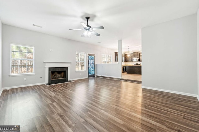 unfurnished living room featuring dark hardwood / wood-style floors and ceiling fan