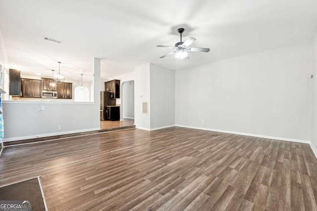 unfurnished living room featuring ceiling fan and dark wood-type flooring