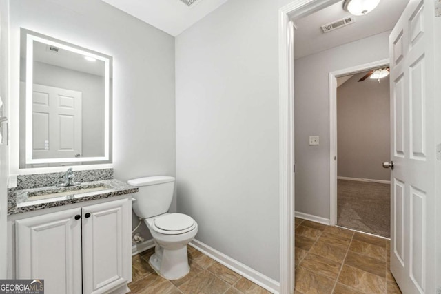 bathroom featuring vanity, toilet, and ceiling fan