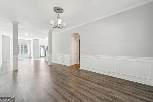 spare room featuring dark hardwood / wood-style flooring, a chandelier, and ornamental molding