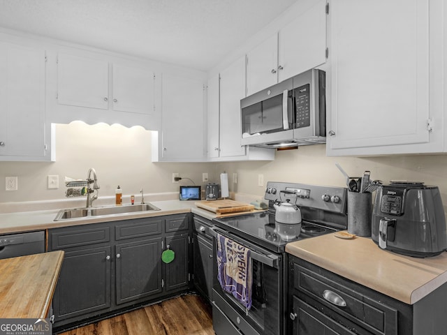 kitchen featuring dark hardwood / wood-style flooring, sink, white cabinetry, and black appliances