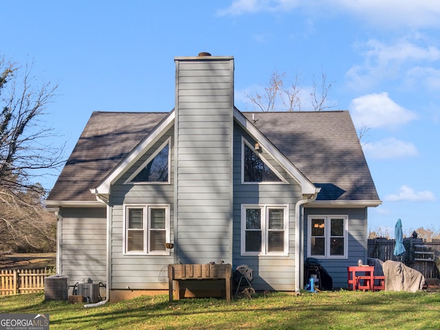 rear view of property featuring a yard and central AC