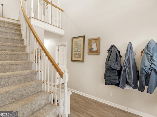 stairway featuring hardwood / wood-style floors and a high ceiling