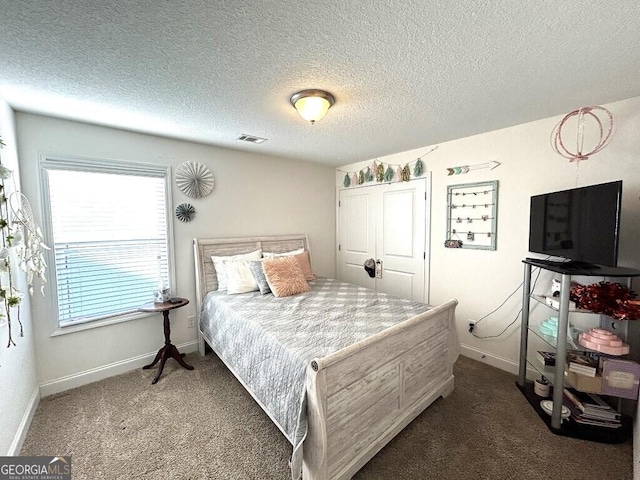 bedroom featuring a textured ceiling and dark carpet