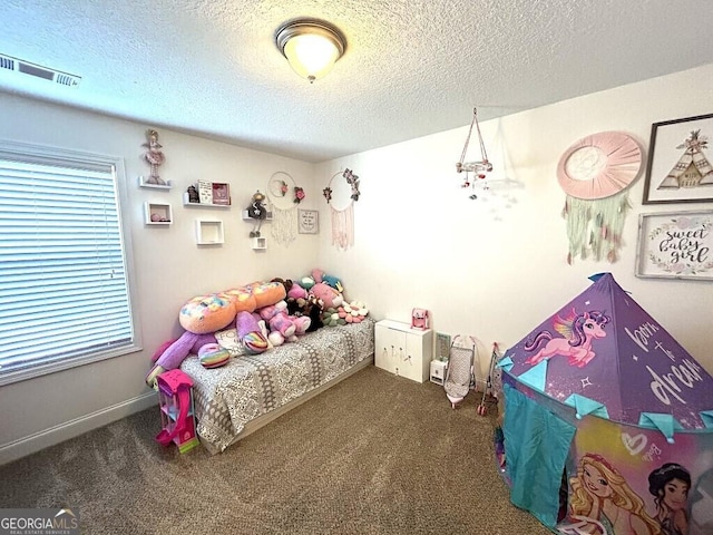 carpeted bedroom featuring multiple windows and a textured ceiling