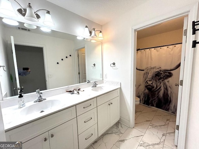 bathroom with a shower with curtain, vanity, a textured ceiling, and toilet