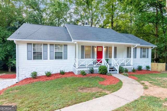 ranch-style home featuring a front lawn and covered porch