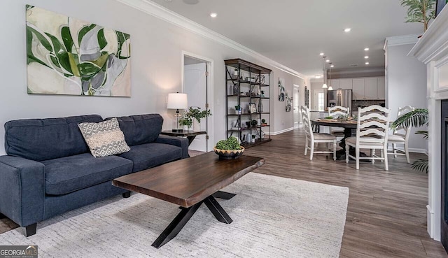 living area with recessed lighting, wood finished floors, baseboards, and ornamental molding