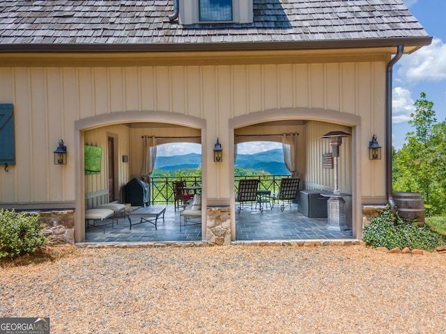 doorway to property with a mountain view and a patio area