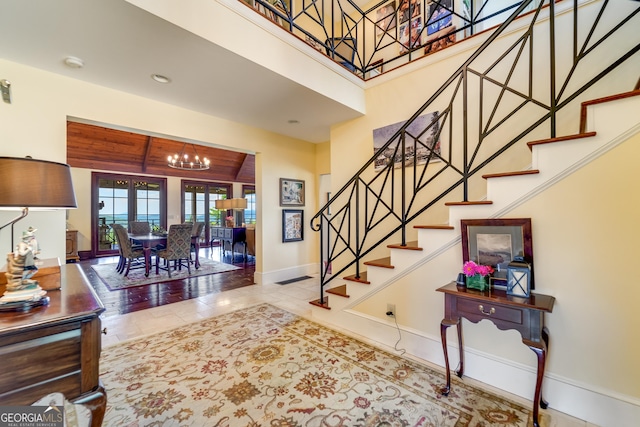 entryway with a chandelier, wood ceiling, and light tile patterned flooring