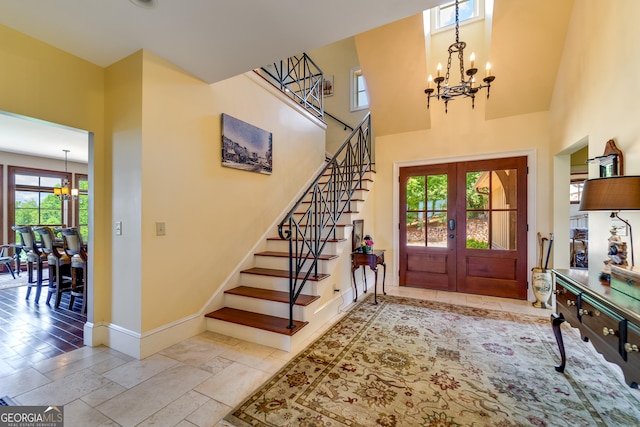 entryway featuring a chandelier, french doors, and a towering ceiling