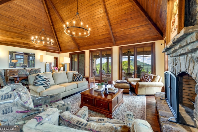 living room with wooden ceiling, a stone fireplace, beamed ceiling, high vaulted ceiling, and a chandelier