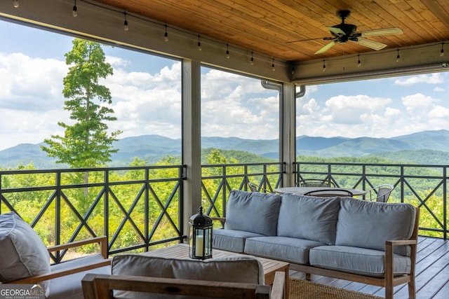 exterior space featuring a mountain view, ceiling fan, wood ceiling, and a wealth of natural light