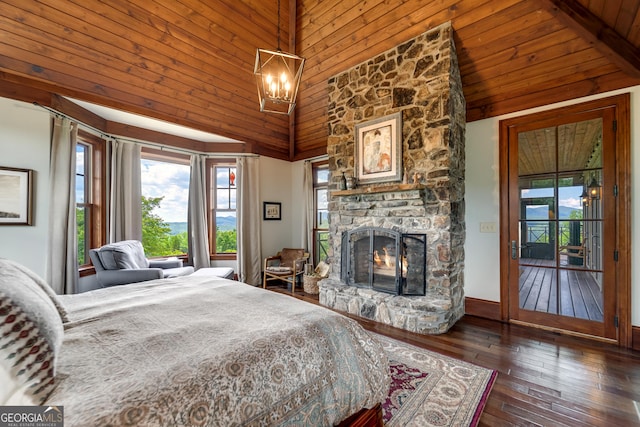 bedroom featuring access to exterior, high vaulted ceiling, dark hardwood / wood-style floors, a notable chandelier, and a fireplace