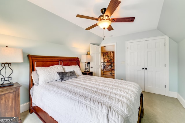 bedroom featuring ceiling fan, a closet, light carpet, and lofted ceiling