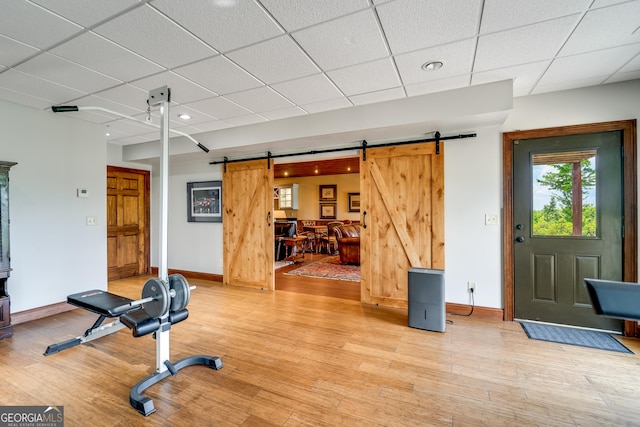 workout room featuring a barn door and hardwood / wood-style floors