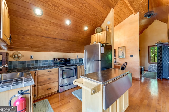 kitchen featuring appliances with stainless steel finishes, wood ceiling, vaulted ceiling, sink, and light hardwood / wood-style flooring