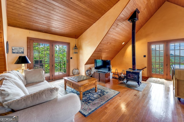 living room featuring a wood stove, french doors, wooden ceiling, high vaulted ceiling, and light wood-type flooring