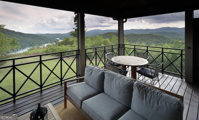 balcony with outdoor lounge area and a water and mountain view