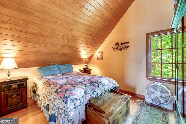 bedroom featuring lofted ceiling, light hardwood / wood-style floors, and wooden ceiling