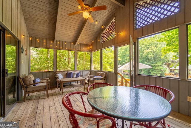 sunroom / solarium with lofted ceiling with beams, plenty of natural light, ceiling fan, and wooden ceiling