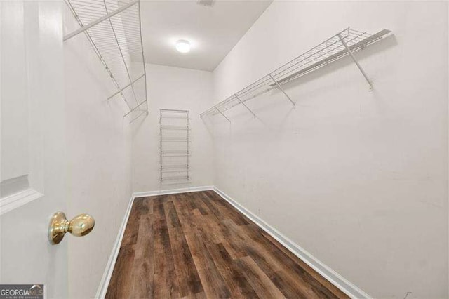 walk in closet with dark wood-type flooring