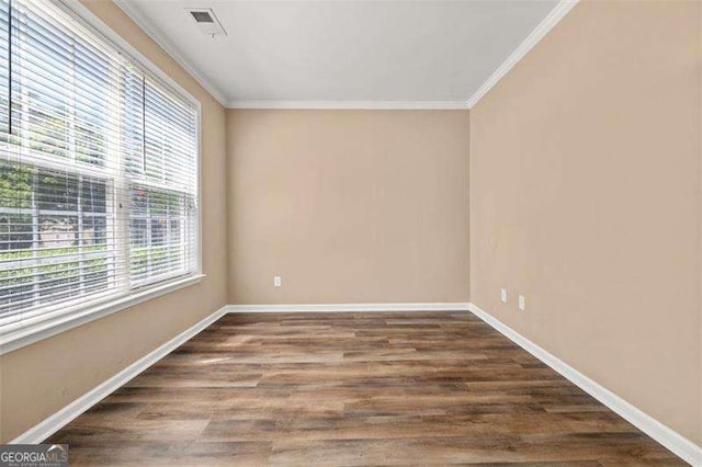 spare room with crown molding and dark wood-type flooring