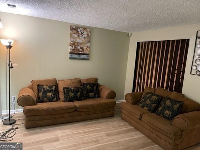 living room featuring light hardwood / wood-style floors and a textured ceiling