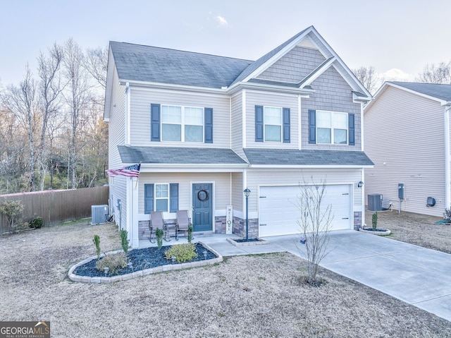 craftsman inspired home featuring an attached garage, fence, cooling unit, and concrete driveway