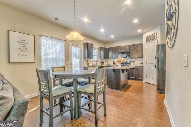 dining space featuring baseboards, recessed lighting, visible vents, and light wood-style floors