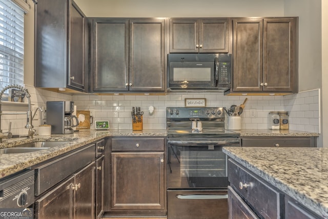 kitchen featuring dark brown cabinetry, a sink, light stone countertops, black appliances, and backsplash