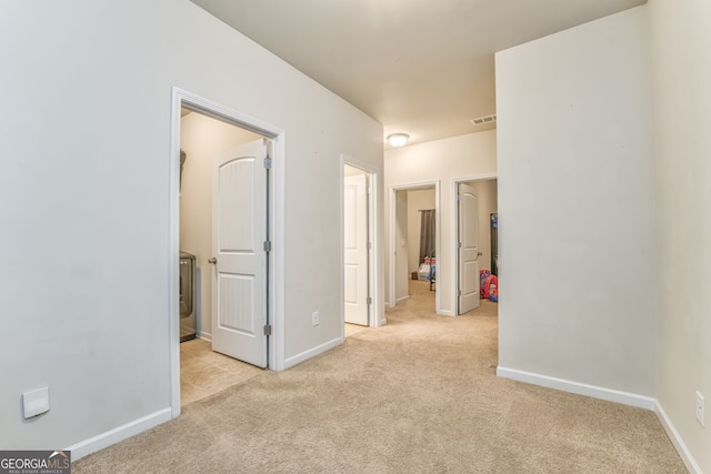 interior space with light carpet, visible vents, and baseboards