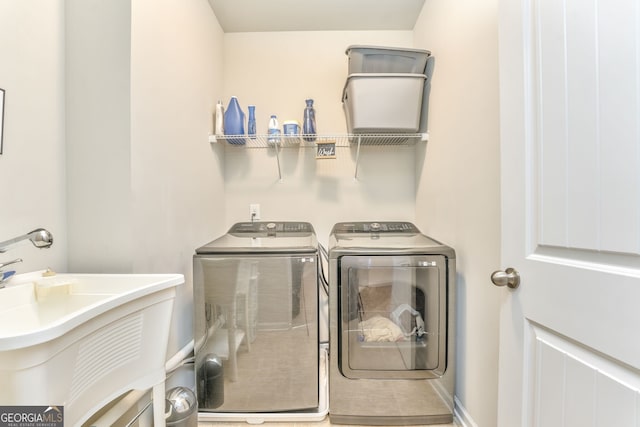 washroom with laundry area, independent washer and dryer, and a sink